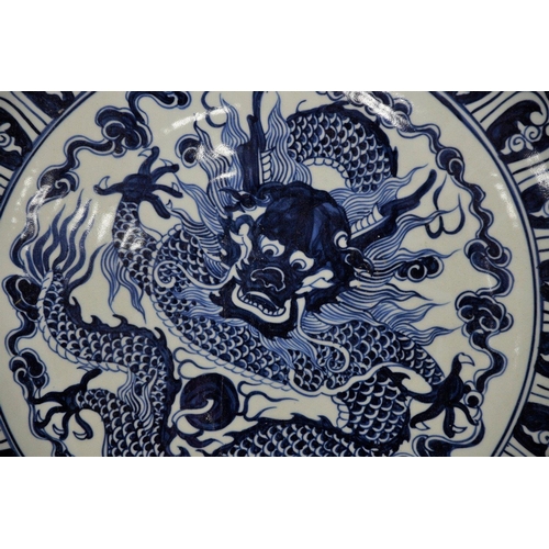 18 - A very heavy large porcelain charger plate with a hand painted dragon design. Approximately 5ft in d... 