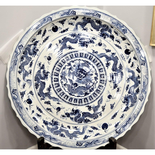 18 - A very heavy large porcelain charger plate with a hand painted dragon design. Approximately 5ft in d... 