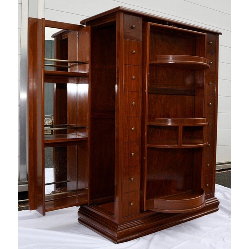 195 - A Chinese rosewood revolving bar in an Art Deco style, it houses various compartments for bottles, g... 