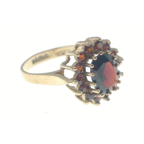 23 - A 375 fully hallmarked gold ring with large centre stone with surrounding red stones (one missing). ... 