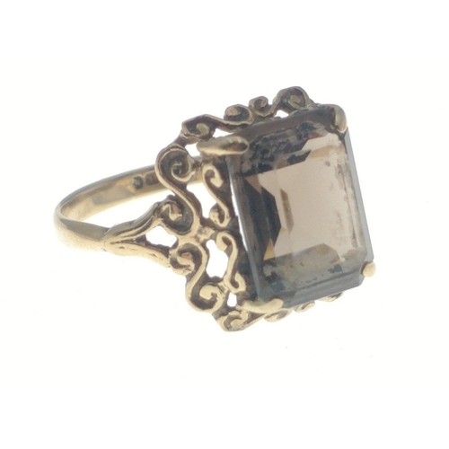 25 - A 9ct fully hallmarked ring with intricate mount and rectangular smokey quartz centre stone.  Size K... 