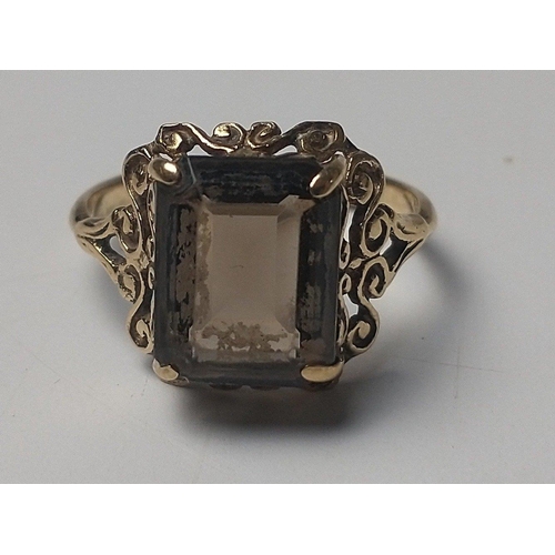 25 - A 9ct fully hallmarked ring with intricate mount and rectangular smokey quartz centre stone.  Size K... 