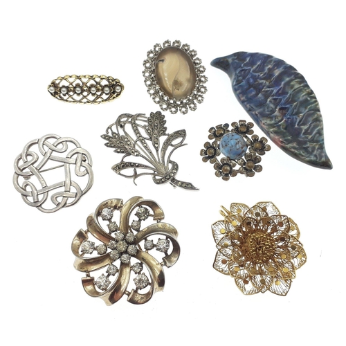 21 - A small decorative lot of brooches to include a Celtic knot, a marcasite leaf, and a small blue hard... 