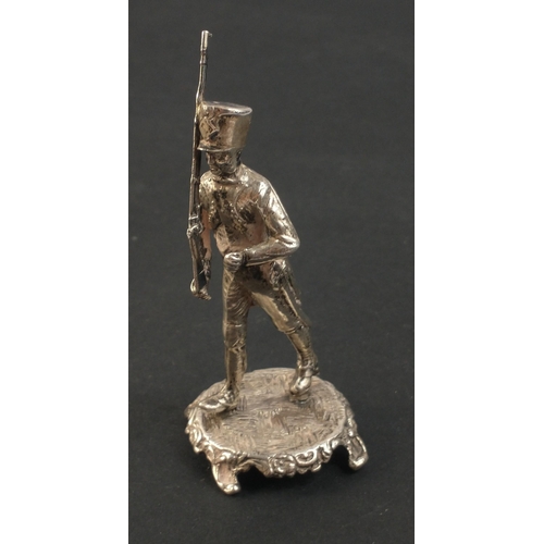 35 - A SILVER stamped and hallmarked marching dragoon foot soldier on a silver base - weight 50.50g appro... 