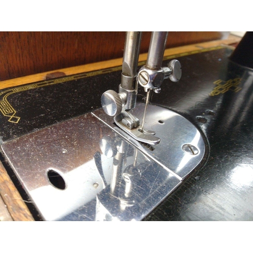 417 - A Singer sewing machine in a dome topped case, manual model with reg no.EB92003 (dating to 1938), li... 