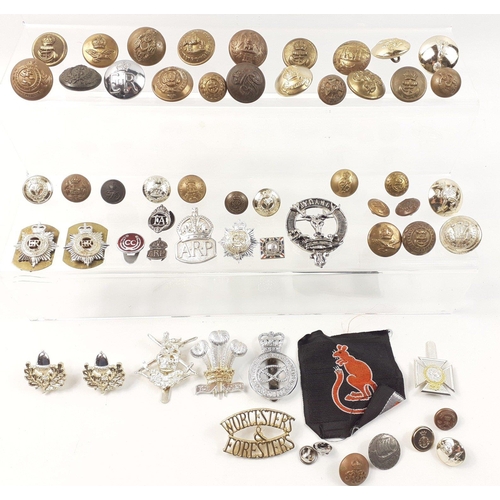 99 - A super small military lot to include some brass uniform buttons, staybrite badges and others as wel... 