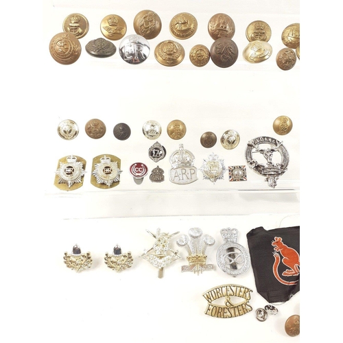 99 - A super small military lot to include some brass uniform buttons, staybrite badges and others as wel... 