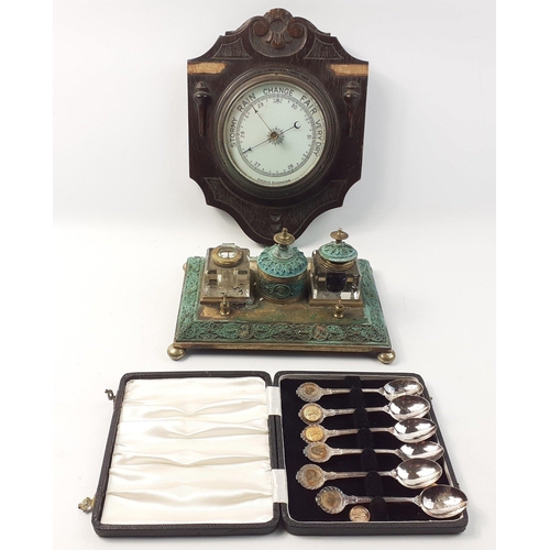 381 - A heavily patinated brass inkwell/ desk stand with a wooden barometer and a cased set of plated golf... 