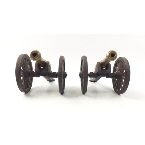 199 - A pair of miniature fireside cannons in iron and brass. Cannon measures13cm and carriage 17cm approx... 