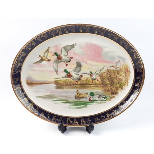 221 - Two COALPORT dishes with exotic birds one green and gilt and the larger cobalt blue and gilt 27cm di... 