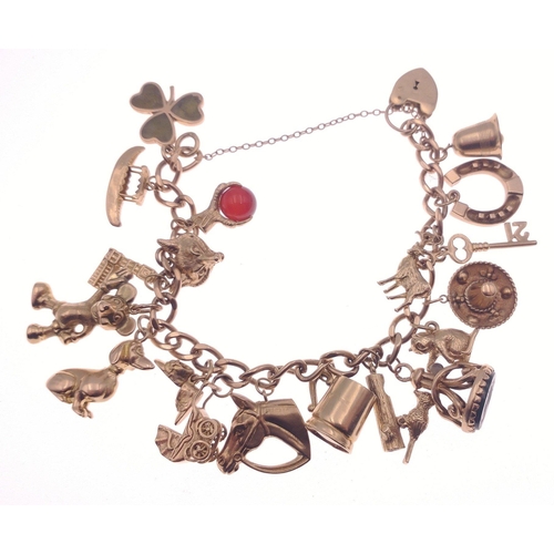 25 - A 375 stamped gold chain bracelet with padlock with no fewer than 19 charms to include a horse, hors... 