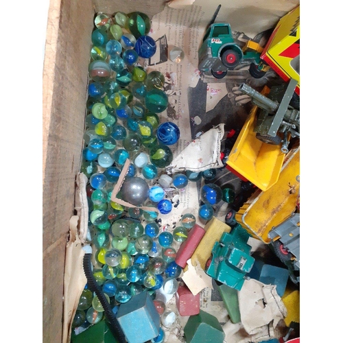 321 - An old wooden storage box containing a quantity of older marbles, building blocks, and some playworn... 