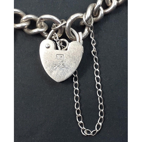 83 - A silver hallmarked chain with heart-shaped lock and 6 charms including a cat, a bell, a map of Scot... 