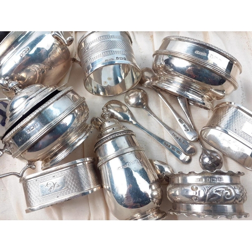 148 - A collection of silver condiment items to include 4 varying napkin rings, 5 condiment spoons, variou... 