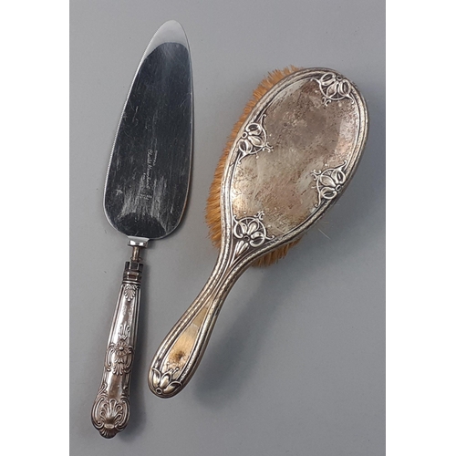 152 - A silver back dressing table brush 22cm long hallmarked London 1918.  Includes a silver handled cake... 