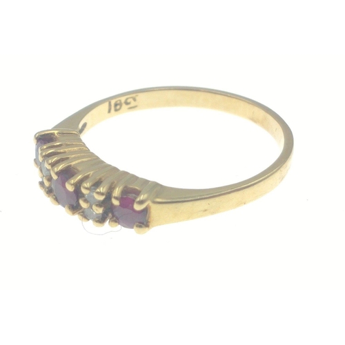 21 - A gold ring stamped 18 set with three garnets interspersed with small diamonds (tested). Size M Gros... 