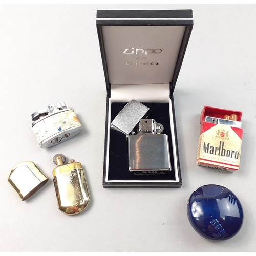 412 - A selection of 5 lighters of interest to include an unused stainless steel ZIPPO.  A lighter in the ... 