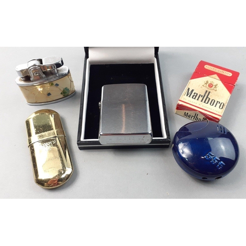 412 - A selection of 5 lighters of interest to include an unused stainless steel ZIPPO.  A lighter in the ... 