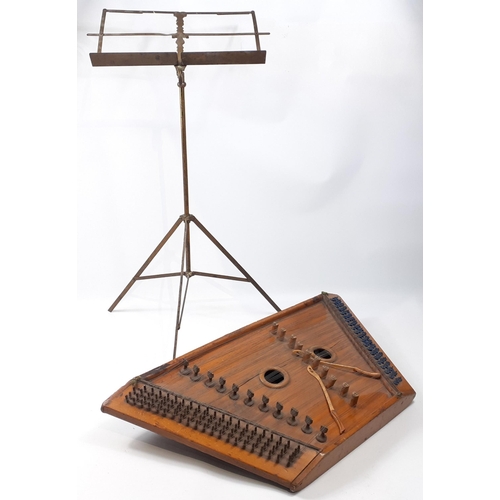 517 - A vintage zither with some damage and signs of wear from storage, presented with a brass music stand... 