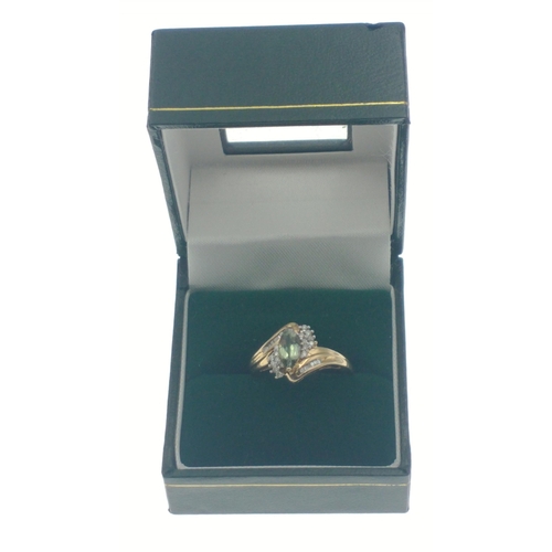 6 - A 9ct hallmarked ring set with an oval green stone surrounded by 2 rows of diamond chips (tested but... 