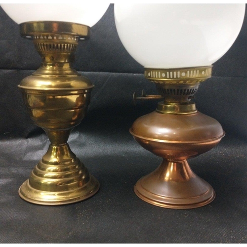 444 - Two oil lamps each with a intact glass globe. One brass effect the other copper.   The larger measur... 