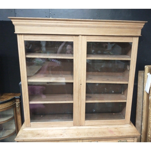 386 - An imposing natural wood dresser with glazed upper with 3 shelves, 2 drawers and a 2 door carved bot... 