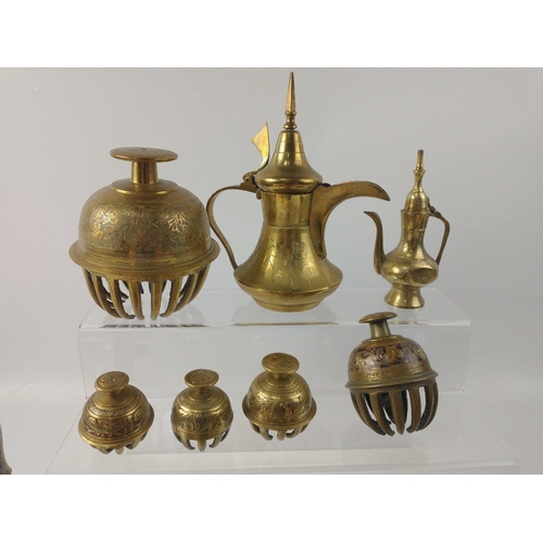 45 - A collection of brass objects to include a set of three bells, Middle Eastern coffee pot, cow bells,... 