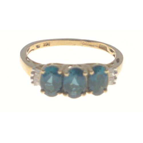 10 - A gold ring stamped 14K with 3 central blue stones with 4 rectangular diamonds to each side, size P,... 