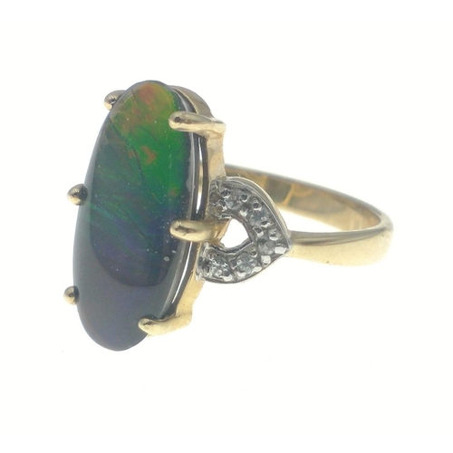 15 - A 10K stamped gold ring with a very attractive oval shaped central multi-coloured stone, size M, gro... 