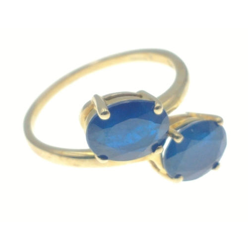 42 - 10k stamped (9ct hallmarked) yellow gold ring set with 2 large offset blue oval stones. Has label 