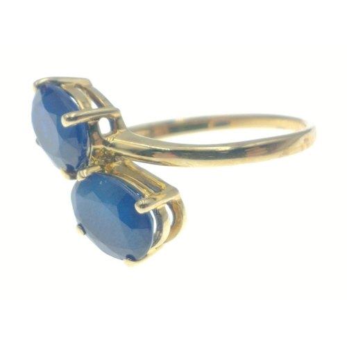 42 - 10k stamped (9ct hallmarked) yellow gold ring set with 2 large offset blue oval stones. Has label 
