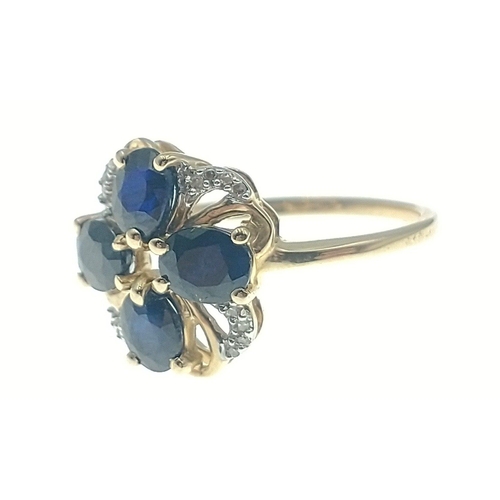 44 - 10k stamped (9ct hallmarked) yellow gold ring set with 4 oval cut blue stones in flower head design ... 