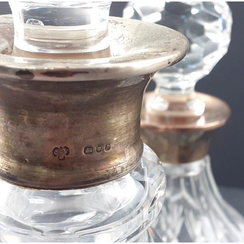 51 - Two silver crystal collared decanters, the larger has a minor chip to the inside of the stopper and ... 