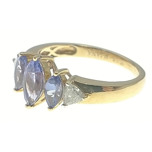 8 - A gold ring stamped Iliana and marked 18K with a trio of attractive navette cut purply blue stones w... 