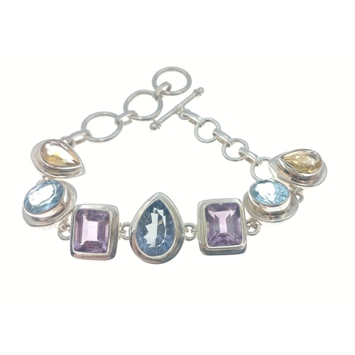 85 - A 925 silver bracelet 18cm approx, attractively set with 7 very pretty coloured stones#85