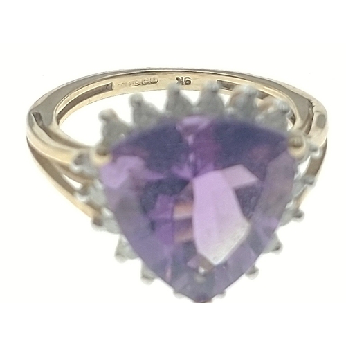 9 - A gold ring hallmarked 9K with a trillion cut central amethyst surrounded by 18 small diamonds (test... 