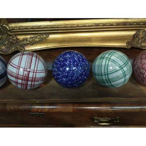 121 - A set of 13 ceramic indoor bowls believed to be WEMYSS, with a display plank with holes for the bowl... 