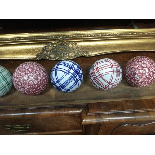 121 - A set of 13 ceramic indoor bowls believed to be WEMYSS, with a display plank with holes for the bowl... 