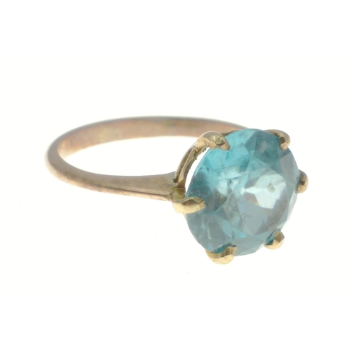 24 - An unmarked quality yellow metal ring with large blue aquamarine style stone - stone dimensions 8mm ... 