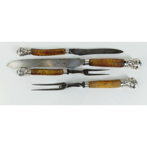 40 - A four piece carving set with horn handles and stunning silver hallmarked rams head finials, Sheffie... 