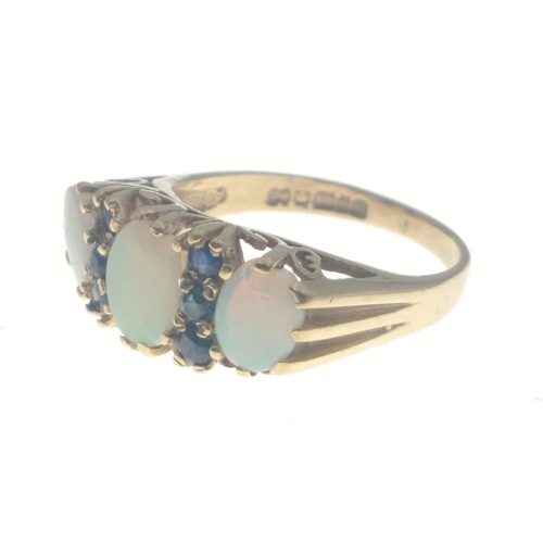 7J - A SUBSTANTIAL 375 stamped OPAL ring with three attractive stones and six small sapphires. The middle... 