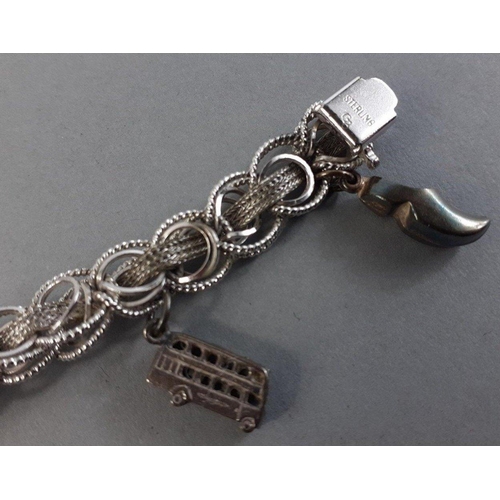 79 - A rather lovely silver charm bracelet with 7 silver charms including a bus, clog, church, and others... 