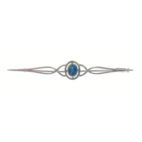 56 - An unmarked bar brooch set with a blue stone, has been jeweller tested as upto 18ct, length 6cm appr... 