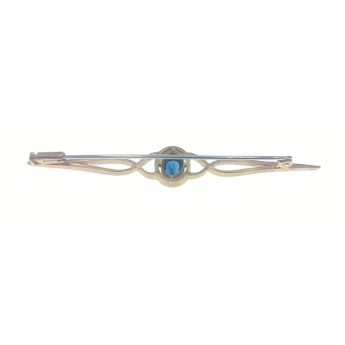 56 - An unmarked bar brooch set with a blue stone, has been jeweller tested as upto 18ct, length 6cm appr... 