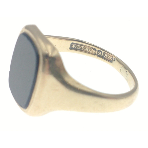 7 - A fully hallmarked 9ct gents gold signet ring with black inset polished centre stone. Size R Gross w... 