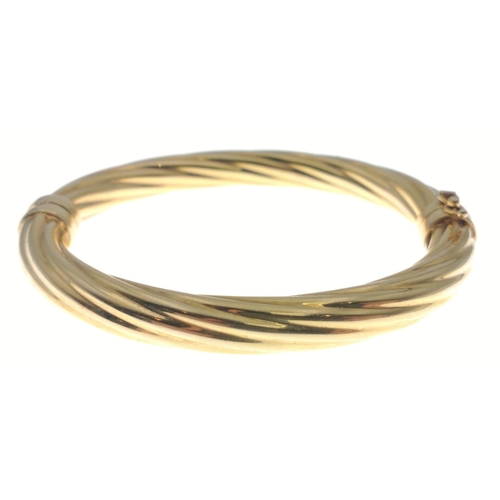 2 - A 9ct gold hollow twisted wire style sprung bangle fitted with a safety clip.  Weight 18.75g approx#... 