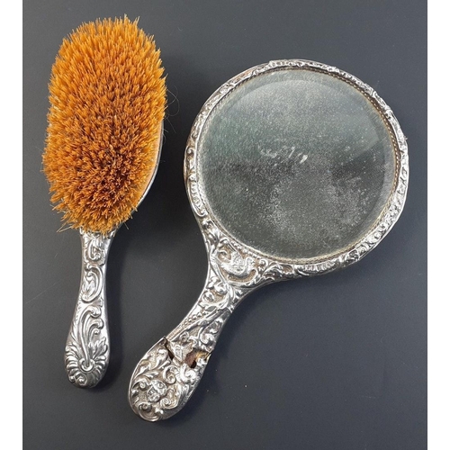 47A - An antique silver dressing table mirror and hairbrush heavily decorated with London 1895 hallmarks, ... 