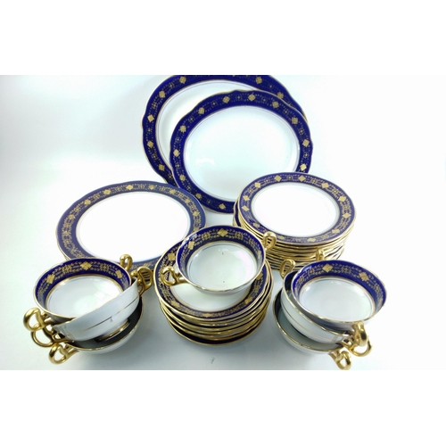 199 - A part dinner service by ROYAL STAFFORD with cobalt blue and gilt edges, comprising 7 twin handled s... 