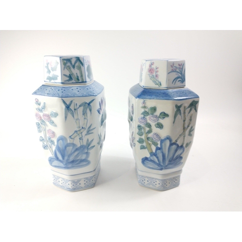 233 - Two Oriental lidded vases with 3D effect lotus and bamboo pattern.  Each stands 31cm tall inc. lids.... 