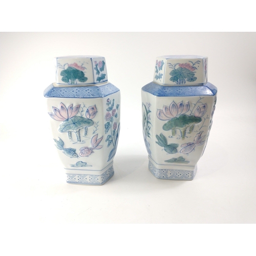 233 - Two Oriental lidded vases with 3D effect lotus and bamboo pattern.  Each stands 31cm tall inc. lids.... 